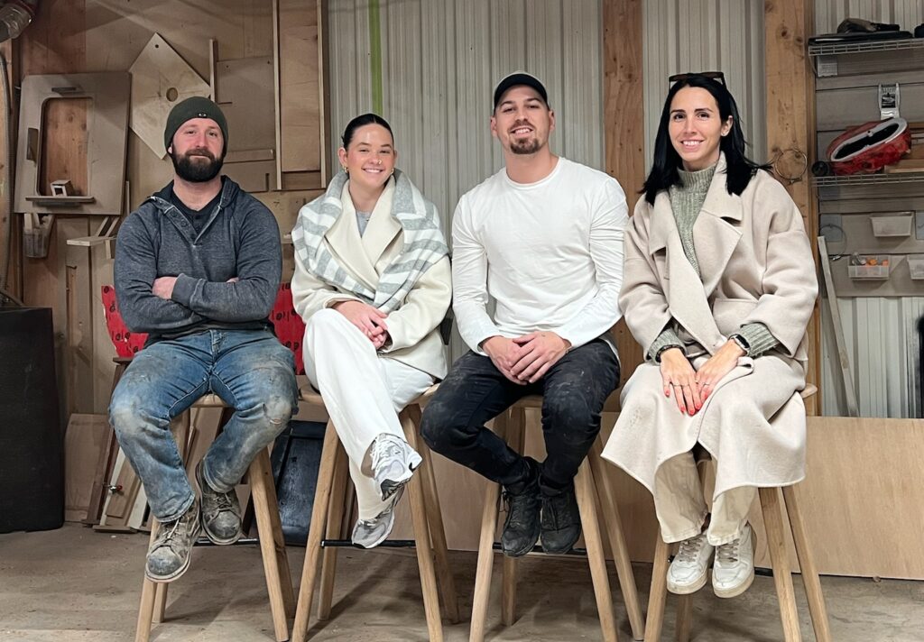 Four Ottawa furniture makers sitting together in their workshop, creators of handcrafted live edge tables.