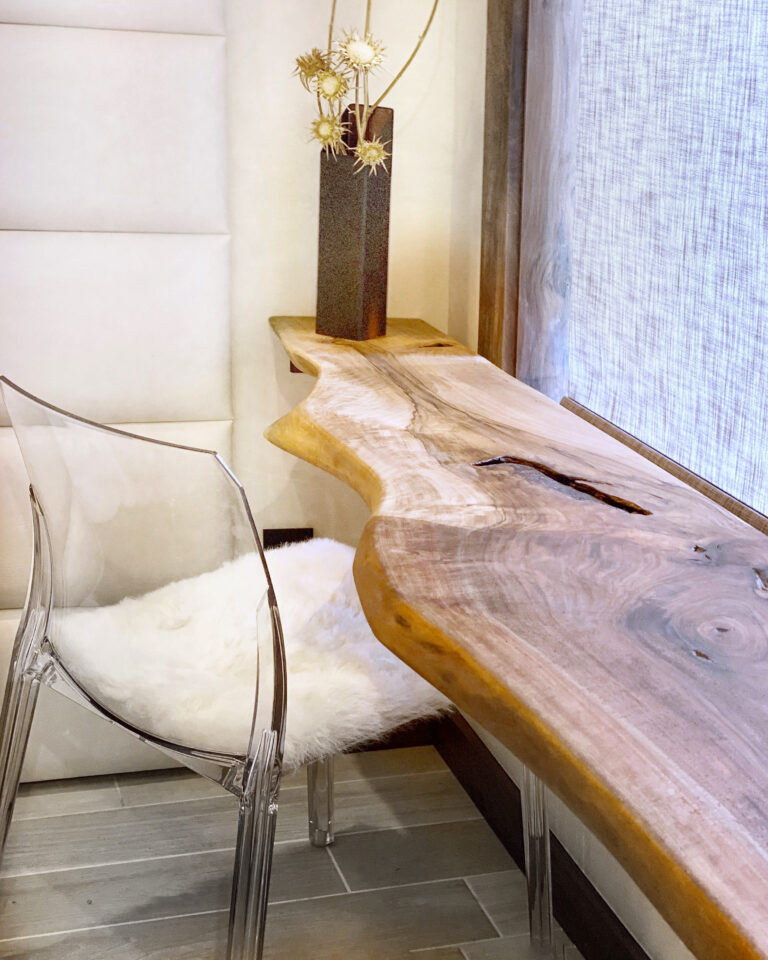 Stylish custom live edge table in Ottawa paired with a clear chair and modern decor by the window.
