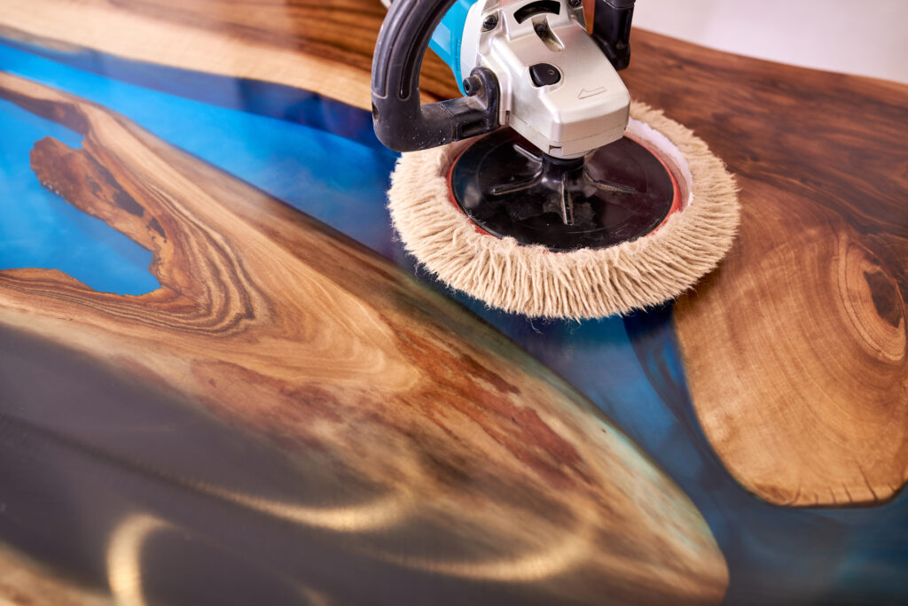 Polishing a custom epoxy and wood live edge table in Ottawa to achieve a high-gloss finish.